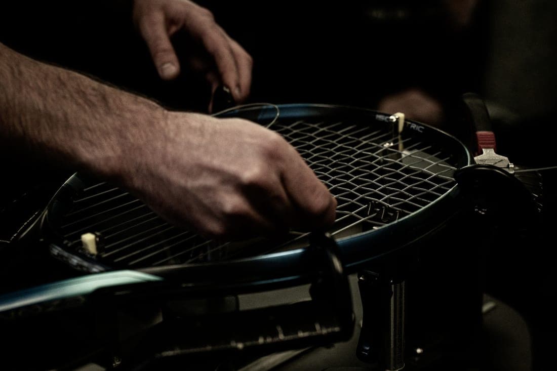 Close-up of a tennis racket string bed in low contrast light